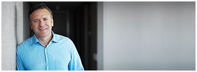 Man smiling while leaning against a wall. Man smiling while leaning against a wall.