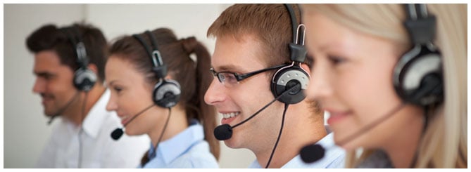 Row of customer service reps smiling with their headsets on Row of customer service reps smiling with their headsets on