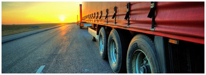 Large Truck Trailer lined up on the highway facing the sunset Large Truck Trailer lined up on the highway facing the sunset